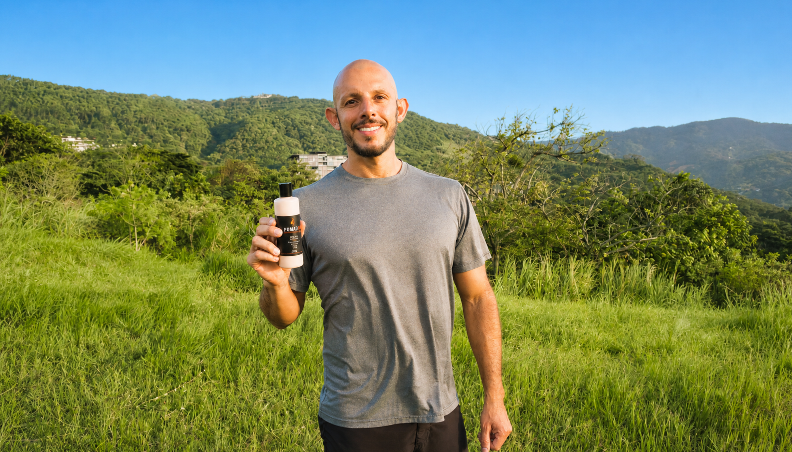 Hombre mostrando Pomada-Ki en paisaje de montañas de Costa Rica